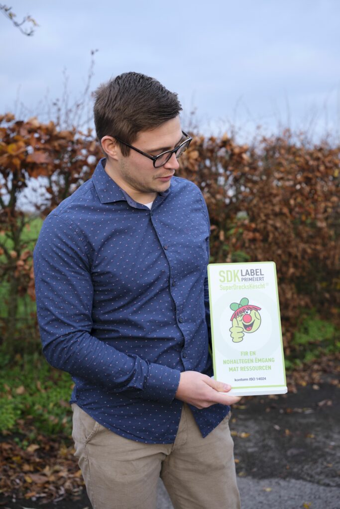 Joé Michels mit dem Zertifikat SuperDrecksKëscht fir Betriber