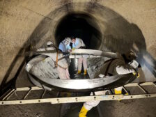 Personen in Schutzkleidung beim Einbau einer DN 3000 Manschette in einen undichten Kanal